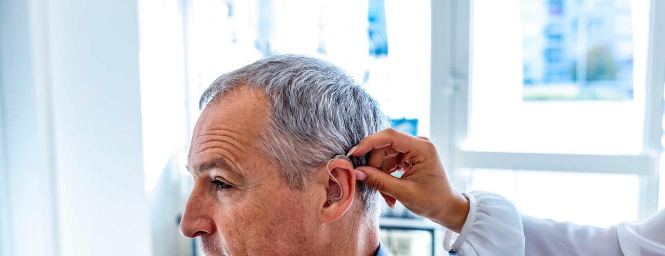Man receiving hearing aid.